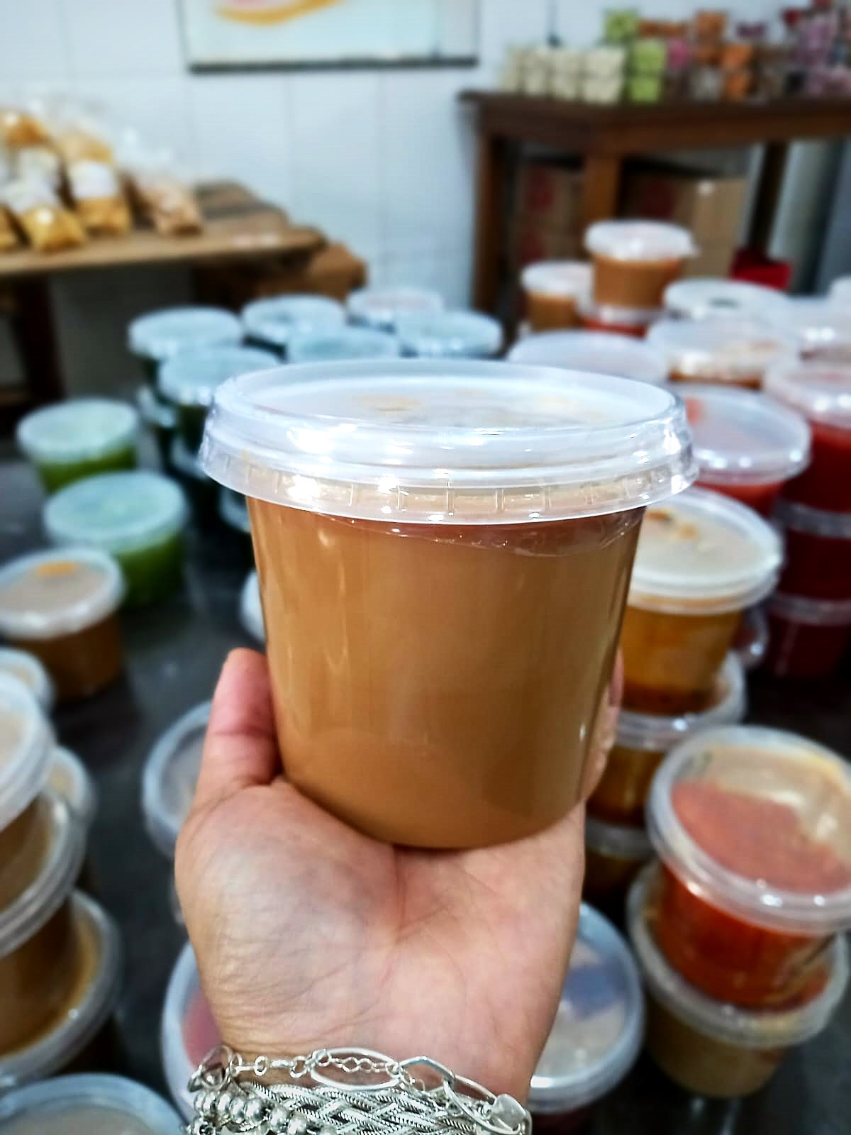 Pote de doce de leite puro cremoso diante das prateleiras de doces